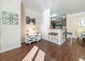 Thumbnail 1 of 29 - A kitchen area with a bar and stools.