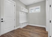Thumbnail 20 of 33 - A room with a white door and a wooden floor.