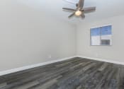 Thumbnail 9 of 22 - an empty living room with wood floors and a ceiling fan