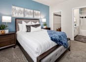 Thumbnail 9 of 25 - A bedroom with a bed, nightstand, and two lamps.