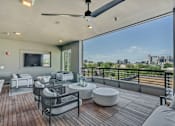 Thumbnail 25 of 29 - A patio with a ceiling fan and a view of the city.