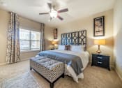 Thumbnail 7 of 29 - A bedroom with a large bed and a ceiling fan.
