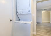 Thumbnail 9 of 20 - a white washer and dryer in a room with a hallway and a door