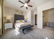 Thumbnail 9 of 29 - A bedroom with a bed, nightstand, and a ceiling fan.