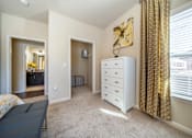 Thumbnail 6 of 29 - A room with a white dresser and a window with gold curtains.