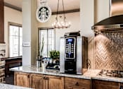Thumbnail 19 of 28 - a kitchen with a coffee machine and a counter top