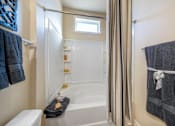 Thumbnail 11 of 29 - A bathroom with a white tub and a window.