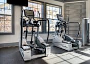 Thumbnail 22 of 29 - A gym with treadmills and elliptical machines.