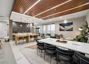 Thumbnail 18 of 26 - A modern dining room with a wooden table and chairs.