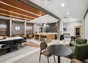 Thumbnail 20 of 26 - A modern dining area with a round table and chairs.