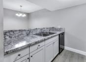 Thumbnail 2 of 33 - a kitchen with white cabinets and granite counter tops and a stainless steel sink