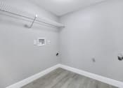 Thumbnail 13 of 33 - an empty room with white walls and wood flooring and a wire shelf on top