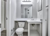 Thumbnail 15 of 33 - a bathroom with a toilet and a sink and a mirror