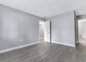 Thumbnail 11 of 33 - an empty living room with white walls and wood flooring