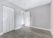 Thumbnail 8 of 33 - an empty room with white closet doors and a door to a hallway