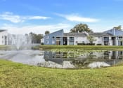 Thumbnail 31 of 33 - a pond with a fountain in front of apartment buildings
