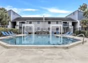 Thumbnail 21 of 33 - a swimming pool with a house in the background