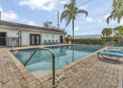 Thumbnail 23 of 29 - a swimming pool with chairs and a house in the background