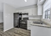 Thumbnail 1 of 29 - an empty kitchen with white cabinets and a black refrigerator