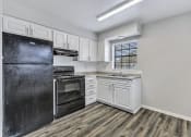 Thumbnail 2 of 29 - an empty kitchen with white cabinets and a black refrigerator