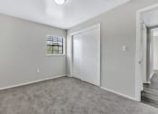 Thumbnail 8 of 29 - a bedroom with white walls and carpet and a door to a closet