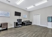 Thumbnail 16 of 29 - a living room with two black chairs and a tv on the wall