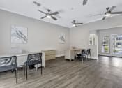 Thumbnail 15 of 29 - a living room with a table and chairs and ceiling fans
