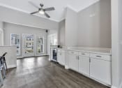 Thumbnail 21 of 29 - a kitchen with white cabinets and a ceiling fan