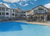 Thumbnail 28 of 29 - a large swimming pool in front of an apartment building