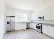 Thumbnail 11 of 26 - a kitchen with white cabinets and stainless steel appliances