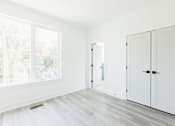 Thumbnail 18 of 26 - an empty room with white walls and a large window
