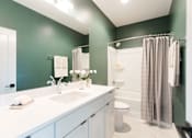 Thumbnail 7 of 26 - a bathroom with green walls and a white sink and toilet