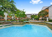 Thumbnail 11 of 19 - a swimming pool at an apartment building with a blue pool
