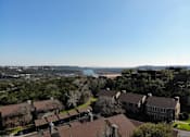 Thumbnail 22 of 30 - A view of a residential area with houses and a body of water in the distance.
