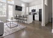 Thumbnail 2 of 11 - A modern living room with a grey couch and a white coffee table.