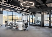 Thumbnail 4 of 35 - A modern office space with a large desk and chairs.