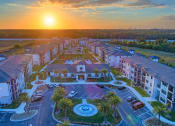 Thumbnail 1 of 23 - an aerial view of an apartment complex with a sunset in the background