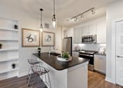 Thumbnail 1 of 33 - A modern kitchen with a black countertop and white cabinets.