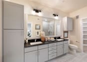 Thumbnail 7 of 33 - A modern bathroom with a large mirror and a sink.