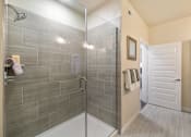 Thumbnail 8 of 33 - A bathroom with a walk in shower and a white door.