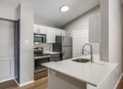 Thumbnail 26 of 29 - a kitchen with white cabinets and stainless steel appliances