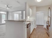 Thumbnail 9 of 17 - a kitchen with an island and a door to a living room