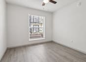 Thumbnail 19 of 38 - Empty room with a window and a fan on the ceiling.