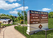 Thumbnail 56 of 62 - a sign for the shops at two rivers at the entrance to a park with cars