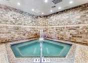 Thumbnail 16 of 62 - a large pool of water in a spa with stone walls