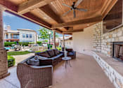 Thumbnail 24 of 62 - a covered patio with couches and a fireplace