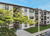 Thumbnail 41 of 42 - A modern apartment building with a parking lot in front.