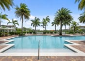Thumbnail 6 of 48 - a swimming pool with palm trees in front of a hotel