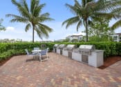 Thumbnail 17 of 48 - a patio with a table and chairs and two gas grills