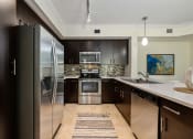 Thumbnail 34 of 48 - a modern kitchen with stainless steel appliances and black cabinets